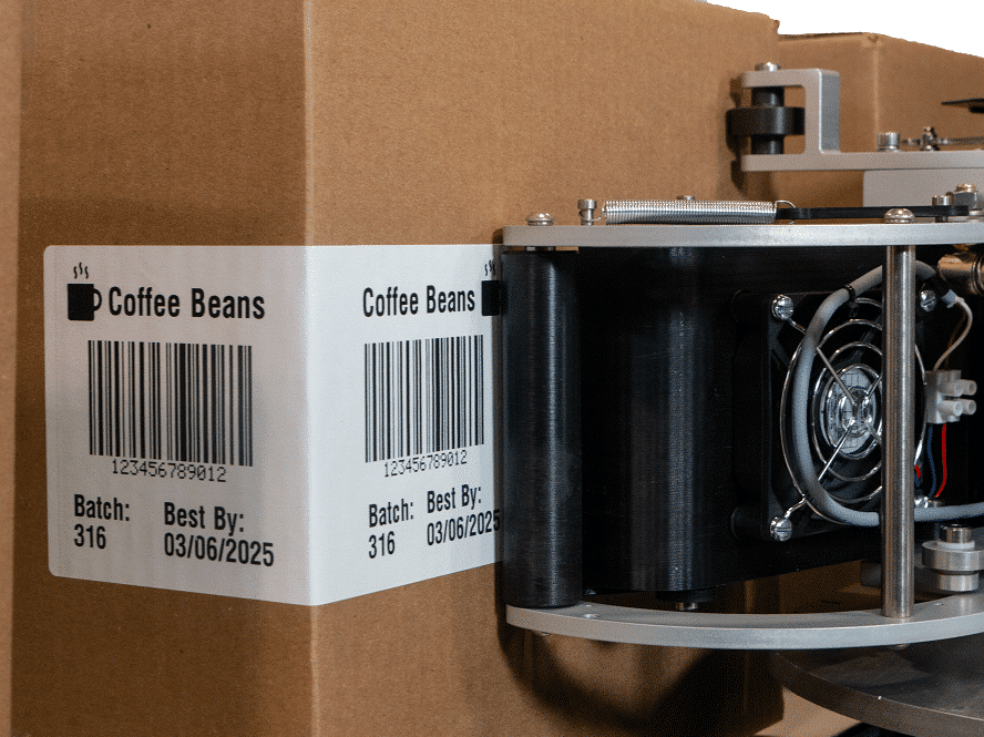 Semi-automatic labeling system with fully electric dispensing function applies label to cardboard box